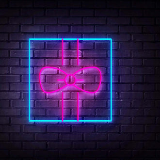 Blue Gift Lid NEON LED Sign featuring a vibrant neon bow design against a dark brick wall.