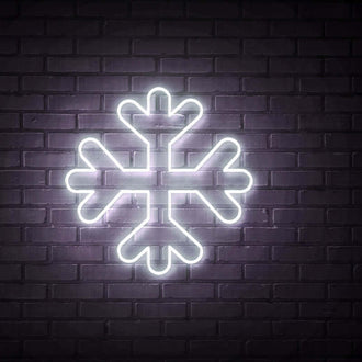 Snowflake NEON LED Sign illuminated on a dark brick wall background, showcasing its design and glow.