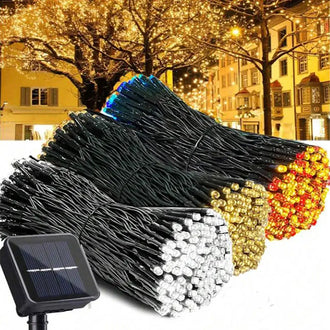 LED Outdoor Solar Fairy Lights - 12m, 100 LED in various colors with solar panel and festive outdoor setting.