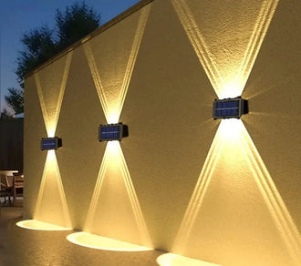 Solar Up & Down Outdoor Wall Light - Single, 12 LED illuminating a stylish yellow wall with warm light.