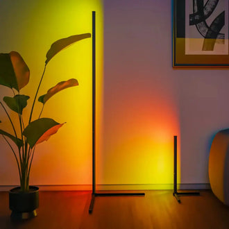 Smart LED Dream Colour Floor Lamp with vibrant colors in a modern living room setting, next to a potted plant.