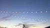 LED string lights glowing in twilight sky, perfect for outdoor settings and events.