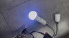 LED smart color-changing bulb glowing blue, with flexible neck and socket, showcasing Bluetooth control features.